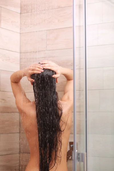 Junge schöne Frau unter der Dusche im Badezimmer. — Stockfoto