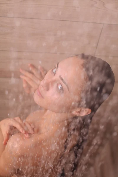 Jonge beautyful vrouw onder de douche in de badkamer. — Stockfoto