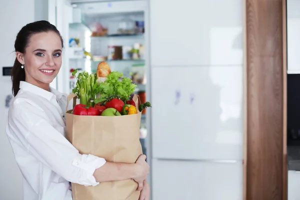 Mujer joven sosteniendo bolsa de la compra de comestibles con verduras. Standi — Foto de Stock