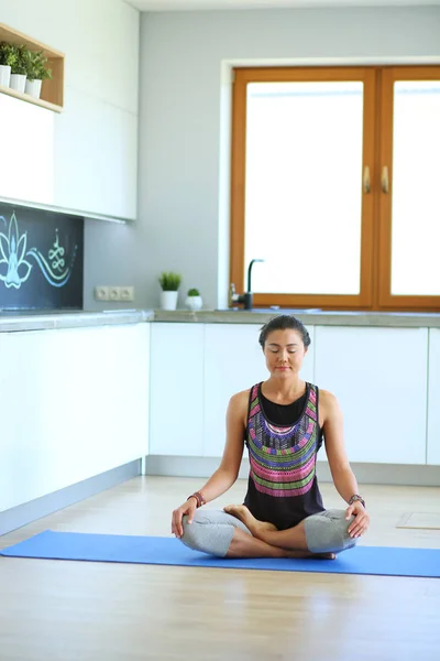 Mujer joven haciendo yoga en casa en la posición de loto. Yoga. Woma. — Foto de Stock