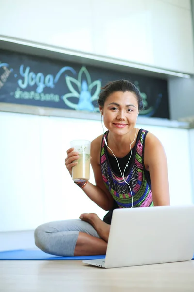 Deportiva mujer sonriente utilizando el ordenador portátil en la habitación luminosa. Una mujer. Estilo de vida — Foto de Stock