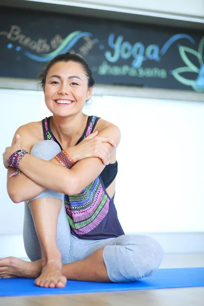 Portrait de femme de yoga souriante assise au tapis de yoga après l'entraînement — Photo