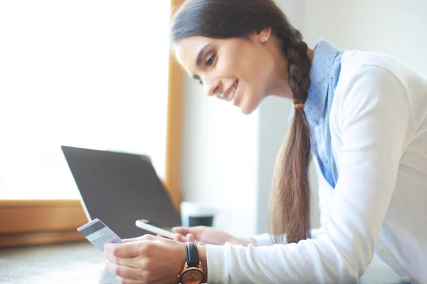 Unga kvinnliga stående nära skrivbord. Kvinna i köket. Arbetsplatsen — Stockfoto