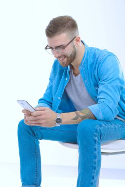 Sandalyede oturan ve cep telefonuyla genç adam. Startupper. Y