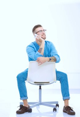 Sandalyede oturan ve cep telefonuyla genç adam. Startupper. Y