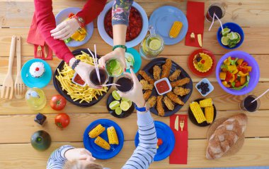 Birlikte yemek yiyen bir grup insanın üst düzey görüntüsü.