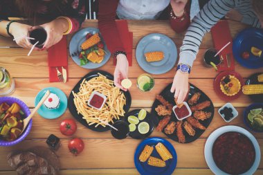 Birlikte yemek yiyen bir grup insanın üst düzey görüntüsü.