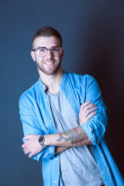 Retrato de um homem casual feliz de pé isolado em um backg escuro — Fotografia de Stock