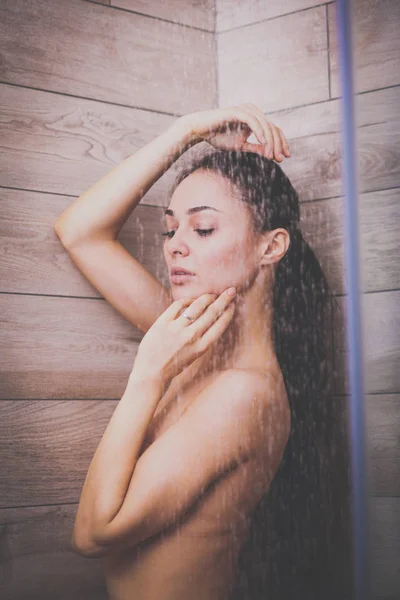Молодая красивая женщина под душем в ванной комнате . — стоковое фото