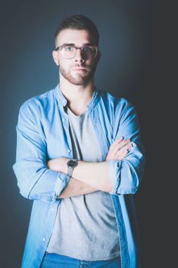 Mutlu bir casual adam ayakta karanlık bir arka plan üzerinde izole portresi. Yakışıklı erkek poz.