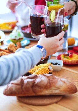 Ahşap masada otururken birlikte yemek yiyen bir grup insanın üst düzey görüntüsü. Masada yemek var. İnsanlar fast food yiyor..