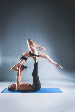 Genç çift Acro yoga mat Studio birlikte uygulamak. Acroyoga. Çift yoga. Ortak yoga.