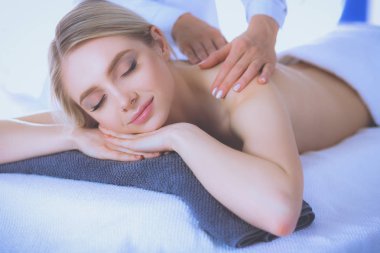 Masaj masasında uzanmış gözleri kapalı rahatlayan genç bir kadın. - Kadın. Spa salonu