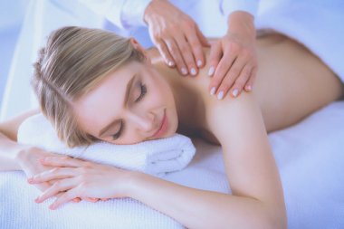 Masaj masasında uzanmış gözleri kapalı rahatlayan genç bir kadın. - Kadın. Spa salonu