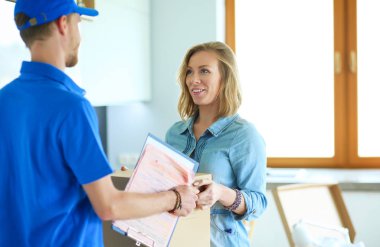 Mavi üniformalı gülümseyen kurye servis konseptine paket kutusu teslim eden teslimatçı.