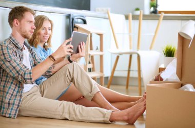 Genç bir çift yeni ev içinde hareket. Katta oturan ve açma sonra rahatlatıcı. Bir şey üstünde laptop arıyorum