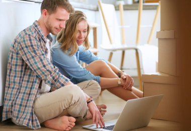 Genç bir çift yeni ev içinde hareket. Katta oturan ve açma sonra rahatlatıcı. Bir şey üstünde laptop arıyorum