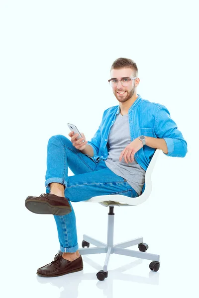 Jonge man zittend op een stoel en met behulp van de mobiele telefoon. Startupper. Jonge ondernemer. — Stockfoto