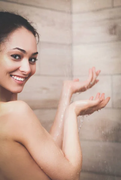 Junge schöne Frau unter der Dusche im Badezimmer. — Stockfoto