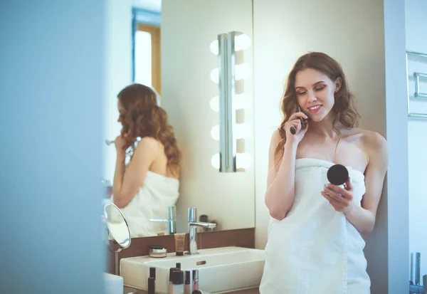 Mujer joven de pie en el baño con teléfono . — Foto de Stock