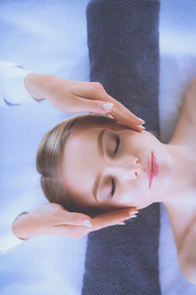 Jeune femme allongée sur une table de massage, relaxante les yeux fermés. Femme. Salon de spa — Photo