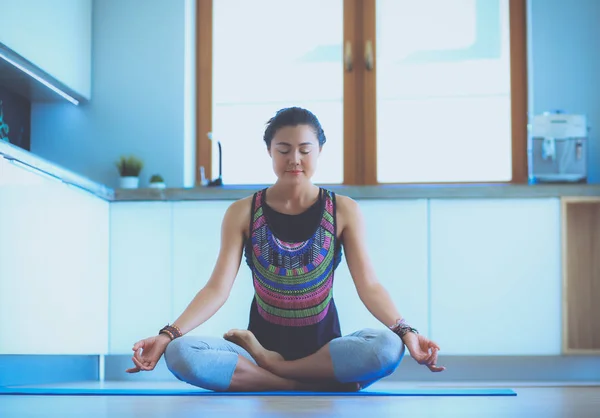 Mujer joven haciendo yoga en casa en la posición de loto. Yoga. Una mujer. Estilo de vida — Foto de Stock