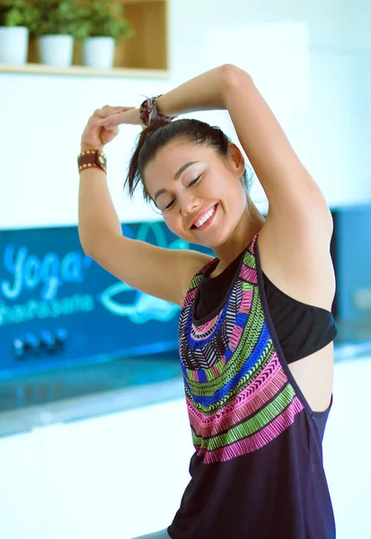 Retrato de una mujer sonriente de yoga sentada en la esterilla de yoga después del entrenamiento en el estudio de yoga. Yoga. Mujer. . — Foto de Stock