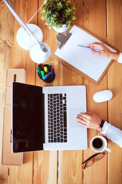 Jeune femme travaillant assise à un bureau. — Photo