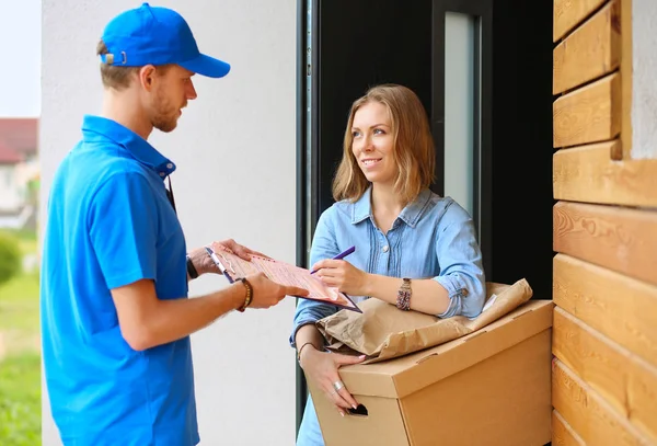 向收件人-信使服务概念提供蓝色制服包裹箱的送货员微笑 — 图库照片