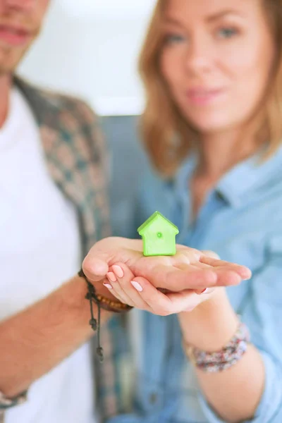 Model domu v ruce pár, stojící v novém domově — Stock fotografie