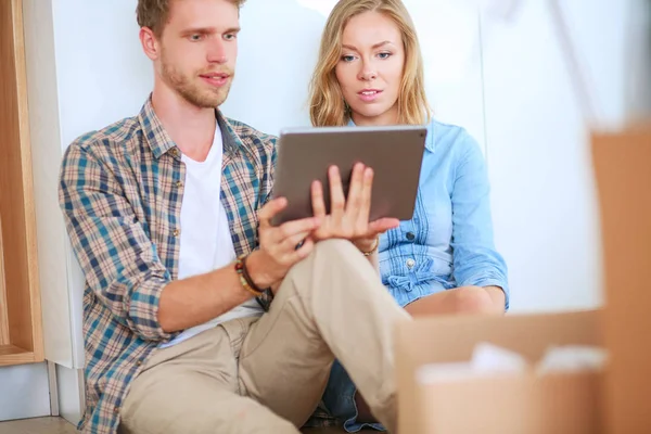 Genç bir çift yeni ev içinde hareket. Katta oturan ve açma sonra rahatlatıcı. Bir şey üstünde laptop arıyorum