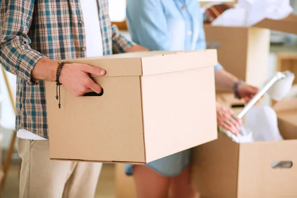 Young couple carrying big cardboard box at new home.Moving house — Stock Photo, Image