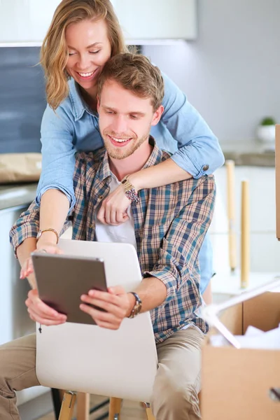 Pasangan muda bergerak di home.Sitting baru dan relaxing setelah unpacking.Looking sesuatu di laptop — Stok Foto