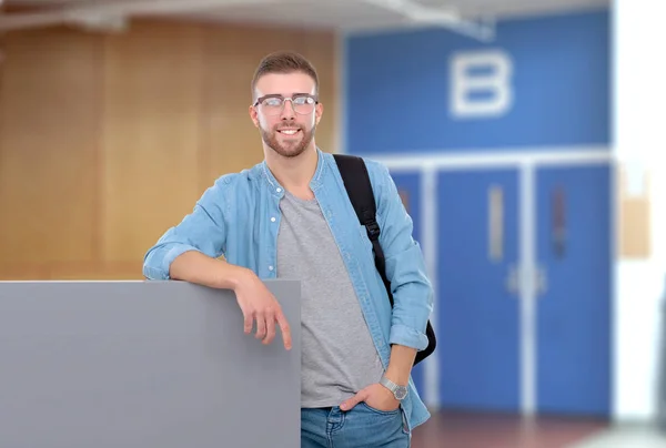 Retrato de un estudiante sonriente sosteniendo un tablero en blanco parado en la calle —  Fotos de Stock