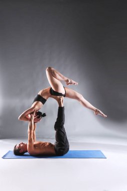 Genç çift Acro yoga mat Studio birlikte uygulamak. Acroyoga. Çift yoga. Ortak yoga.