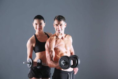 Atletik erkek ve kadın ile bir dumbells. Kişisel fitness eğitmeni. Kişisel eğitim.