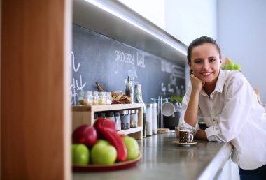 mutfak arka planı duran genç bir kadın portresi.