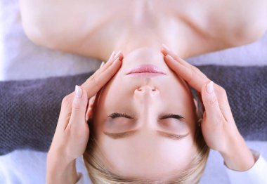 Masaj masasında uzanmış gözleri kapalı rahatlayan genç bir kadın. - Kadın. Spa salonu