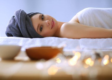 Masaj masasında uzanmış gözleri kapalı rahatlayan genç bir kadın. - Kadın. Spa salonu