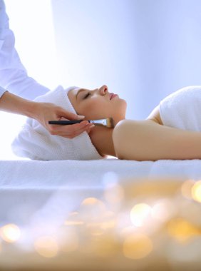 Masaj masasında uzanmış gözleri kapalı rahatlayan genç bir kadın. - Kadın. Spa salonu