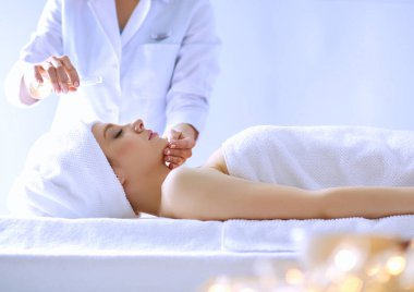 Masaj masasında uzanmış gözleri kapalı rahatlayan genç bir kadın. - Kadın. Spa salonu