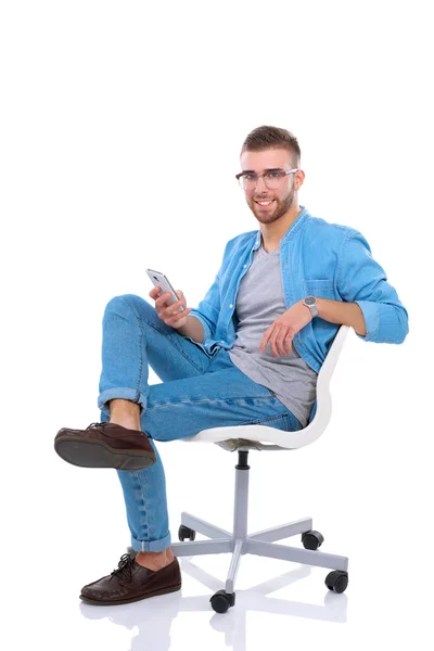 Giovane seduto sulla sedia e utilizzando il telefono cellulare. Startupper. Giovane imprenditore . — Foto Stock