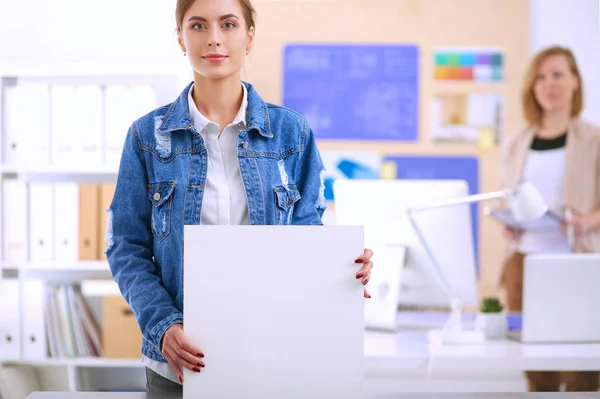 Zwei junge Frauen stehen neben Schreibtisch mit Instrumenten, Plan und Laptop. — Stockfoto