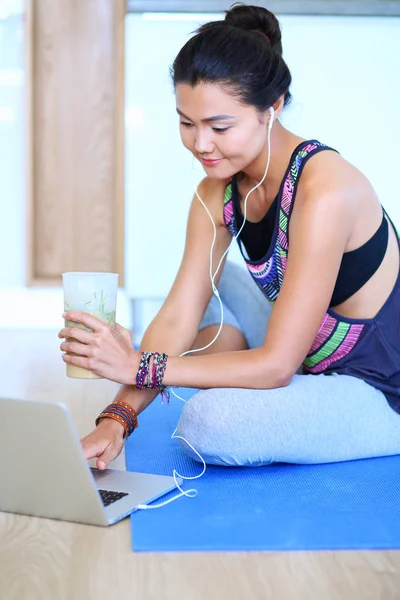 Deportiva mujer sonriente utilizando el ordenador portátil en la habitación luminosa. Una mujer. Estilo de vida — Foto de Stock