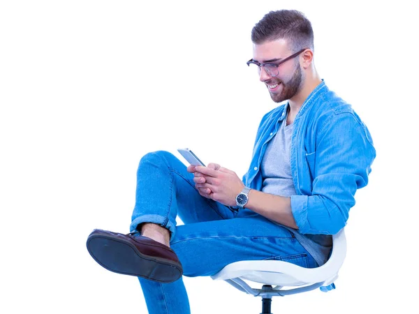 Young man sitting on chair and using mobile phone — Stock Photo, Image