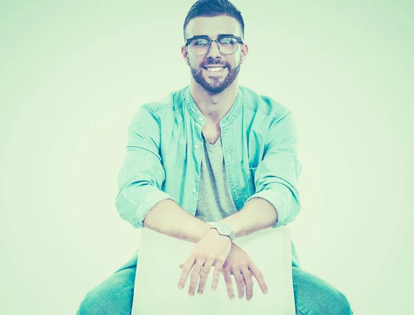 Young man sitting on the chair isolated over white background — Stock Photo, Image