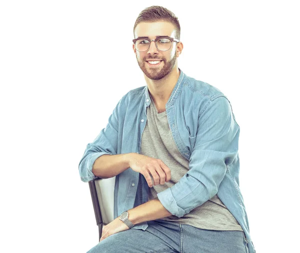 Young man sitting on the chair isolated over white background — Stock Photo, Image