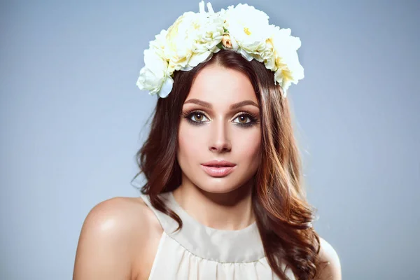 Portrait of a beautiful woman with flowers in her hair — Stock Photo, Image