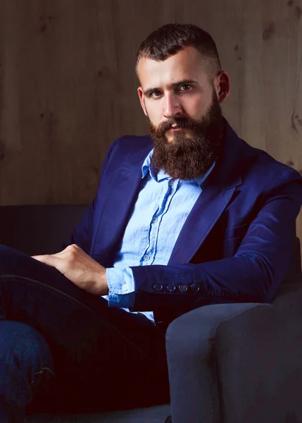 Businessman sitting the sofa in office lobby, isolated on dark background — Stock Photo, Image