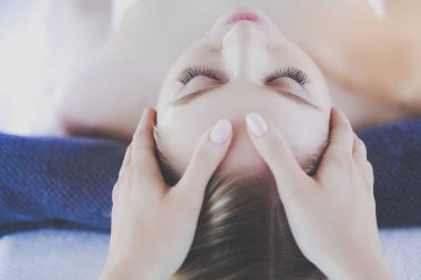 Masaj masasında uzanmış gözleri kapalı rahatlayan genç bir kadın. - Kadın. Spa salonu